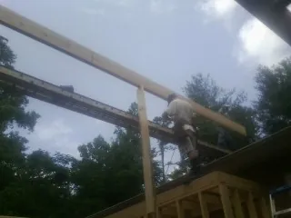 Carpenter setting a ridge beam over a new addition frame — Ice Dam Removal by Roofing Brothers in Montreat