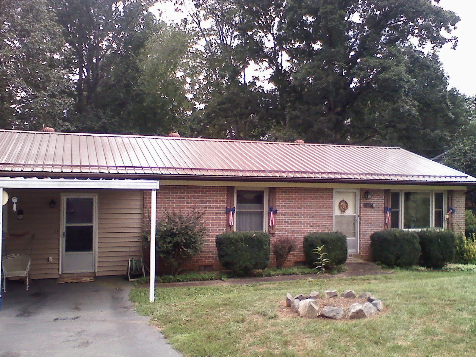 Bronze metal roof and carport on a brick ranch home — Roof Repair work by our crew in Montreat